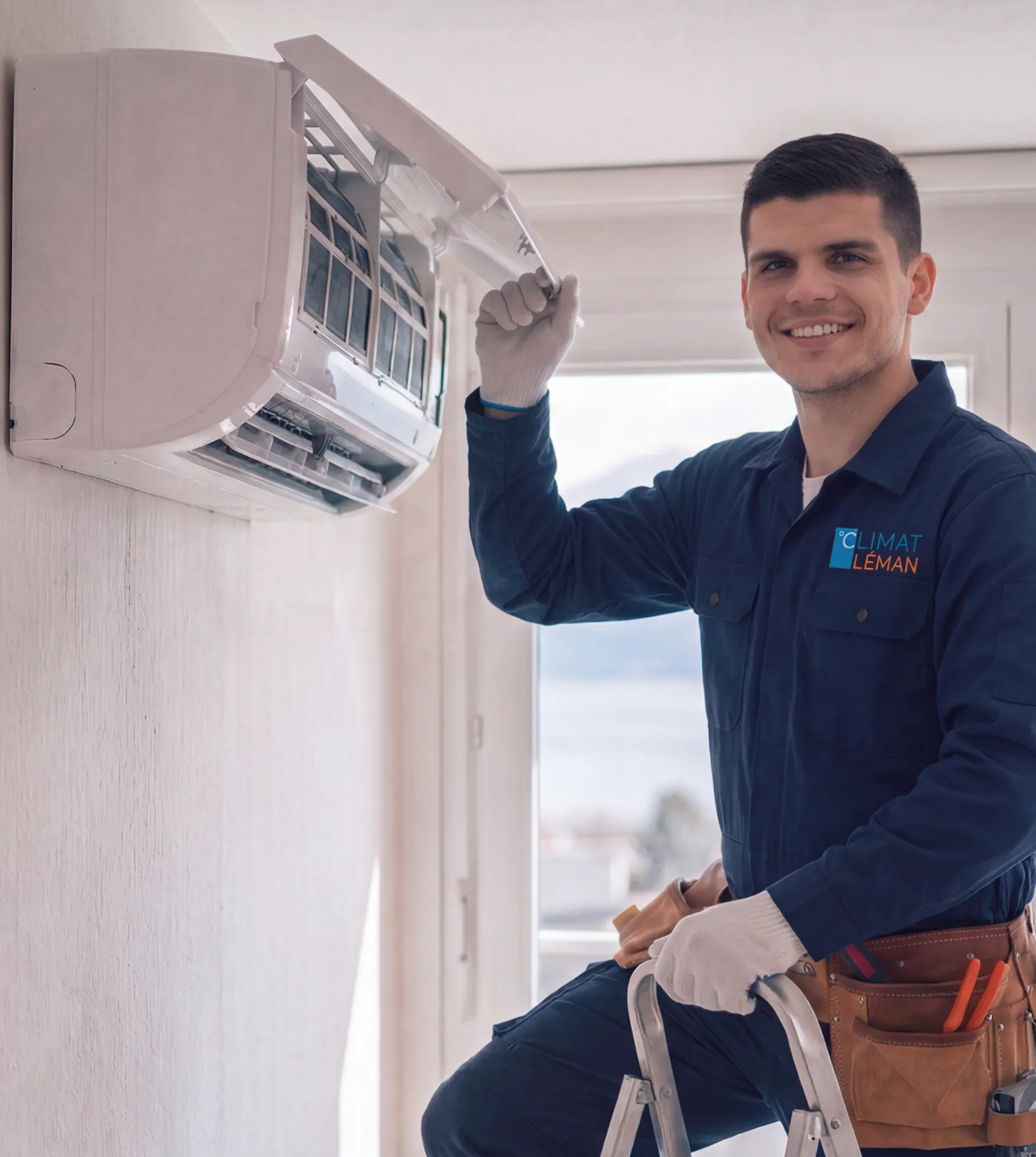 Climat Léman technician assembling a wall-mounted air conditioning unit in a Swiss apartment overlooking Lake Geneva